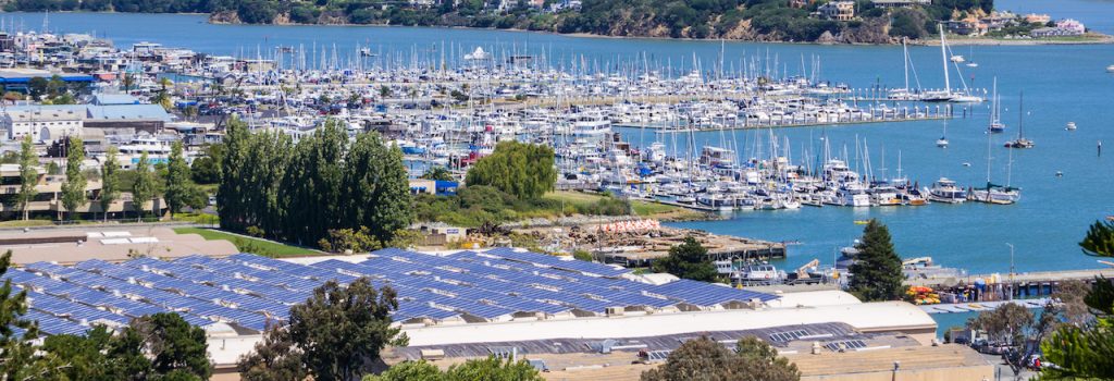 An aerial view showcasing solar panels installed on the rooftop of a building at San Francisco harbor California marina.