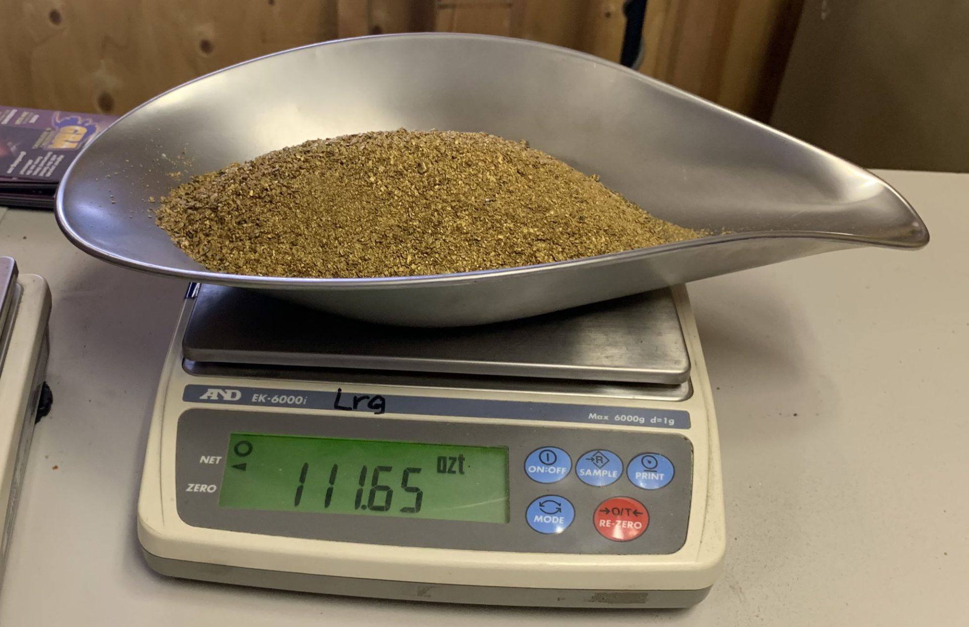 Gold concentrate heaped in the steel pan of a scale